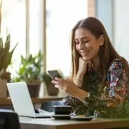 Frau an Handy und PC bei einer Online Lidberatung